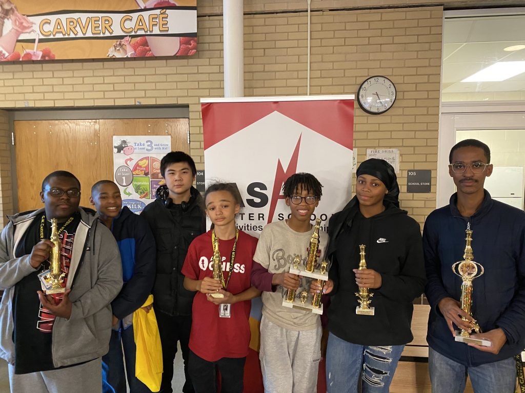 Students posing with chess trophy